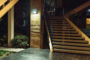 Lit concrete steps with glass railing.