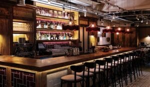 Bar counter with stools and red lights.