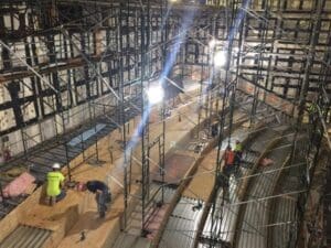 Workers installing theater seating scaffolding.