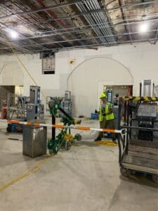 Construction workers and equipment indoors.