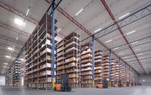 Large warehouse with shelves and forklifts.