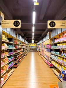 Supermarket aisle with various products displayed.