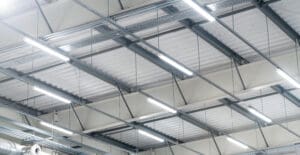 Industrial ceiling with fluorescent lights and beams.