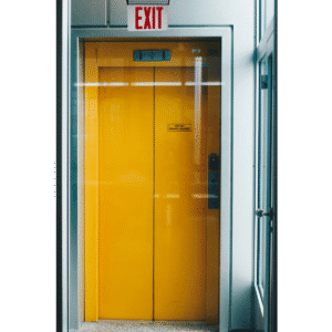 Yellow elevator doors beneath exit sign.